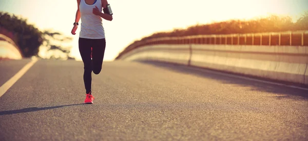 Mulher fitness na estrada do nascer do sol — Fotografia de Stock