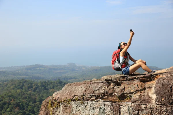 Kvinnan backpacker tar foto på berg — Stockfoto