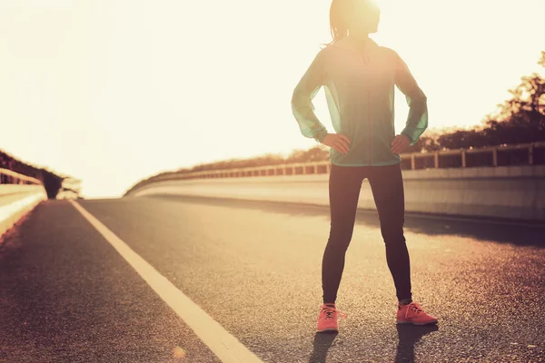 Жінка бігун з руками на стегнах на дорозі — стокове фото