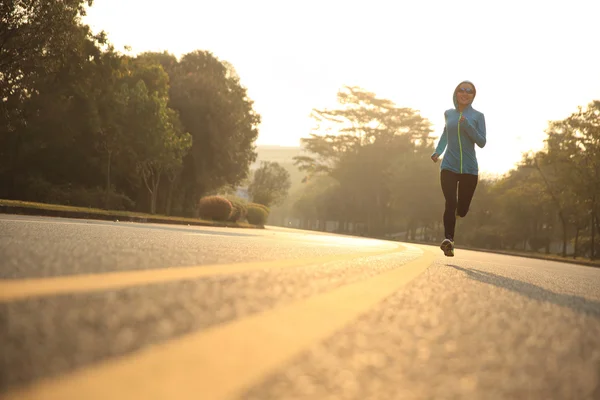 Jeune femme courant sur la route — Photo