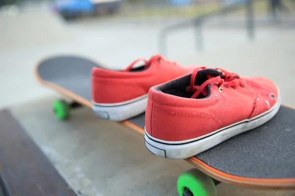 Zapatillas de deporte y patineta en skate park —  Fotos de Stock