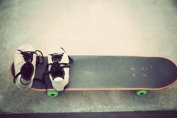 Zapatillas de deporte y patineta en skate park — Foto de Stock