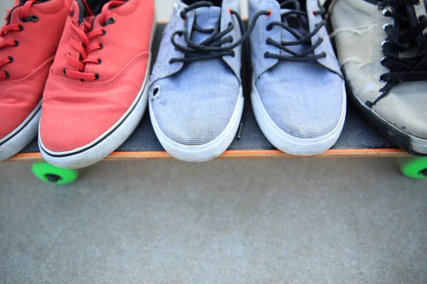 Sneakers and skateboard at skate park — Stock Photo, Image