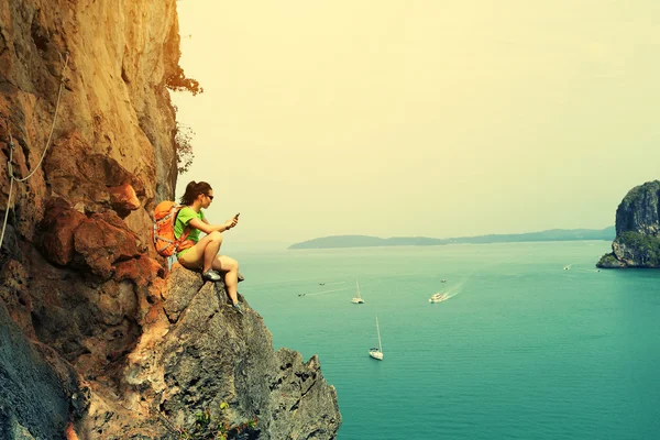 Kvinnan klättrare med smartphone — Stockfoto