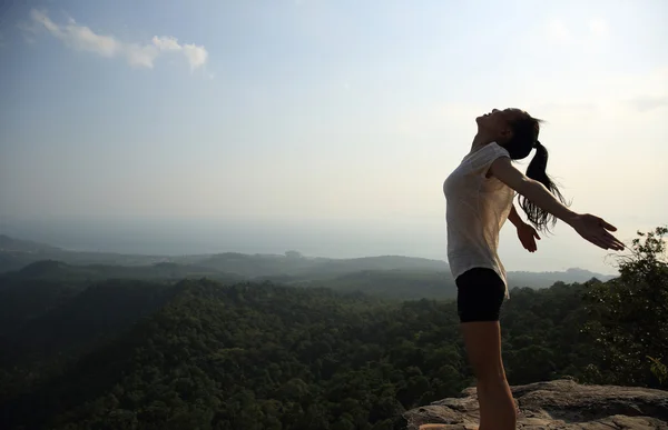 Mujer con los brazos abiertos en la montaña — Foto de Stock