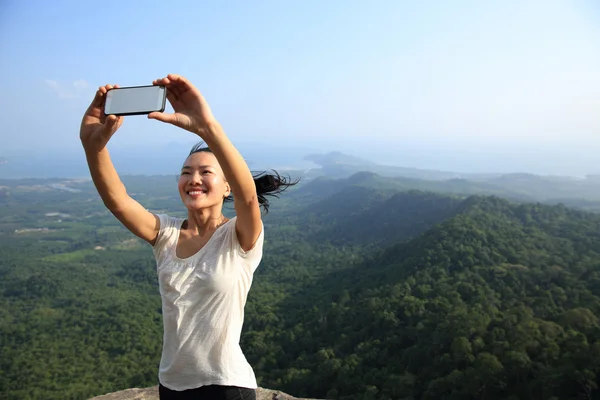 Mujer tomando fotos en la montaña — Foto de Stock