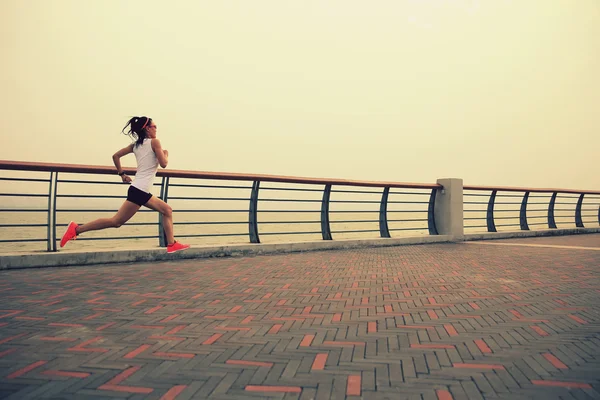Женщина-бегун на берегу моря — стоковое фото