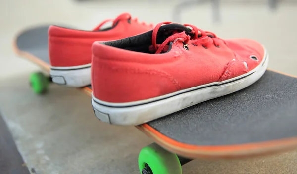 Scarpe da ginnastica e skateboard allo skatepar — Foto Stock