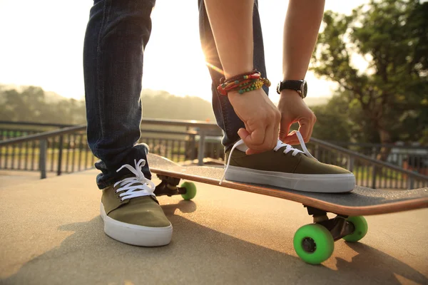 Skateboarder tying shoelace — Stock Photo, Image