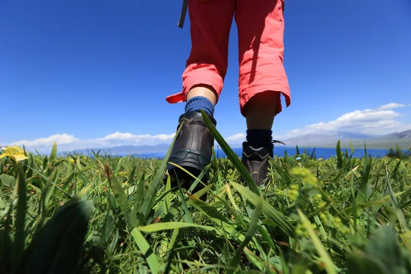 Pernas de caminhante em um topo de montanha grama — Fotografia de Stock
