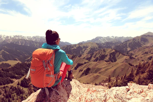 Backpacker sitter på bergstopp — Stockfoto
