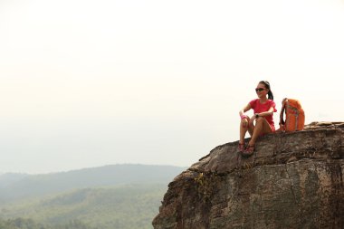 dağ tepe üzerinde oturan backpacker 