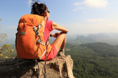 dağ tepe üzerinde oturan backpacker 