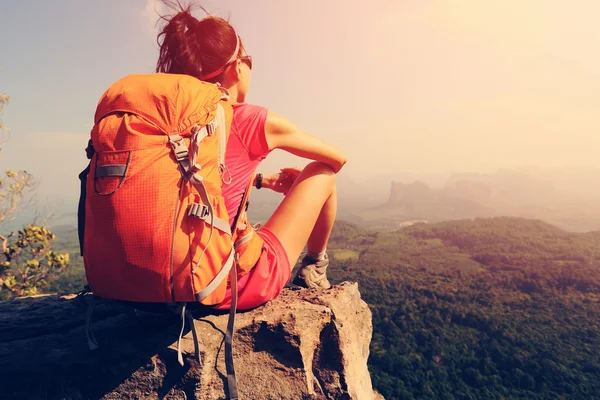 Backpacker sitter på bergstopp — Stockfoto