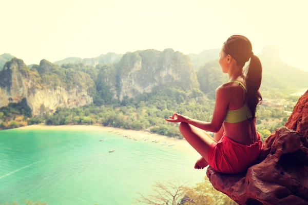 Mujer practicando yoga en pico de montaña —  Fotos de Stock