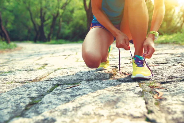 Woman trail runner tying shoelaces — Stock Photo, Image