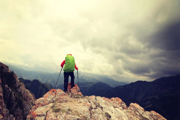 Backpacker vandring på berget peak klippa — Stockfoto