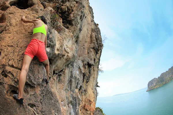 Femme grimpant au bord de la mer — Photo