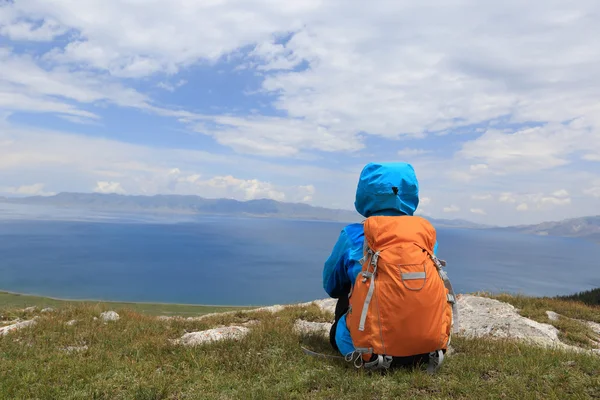 Backpacker sitting on mountain peak — Stock Photo, Image