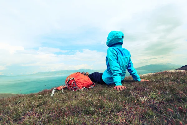 Mochileiro sentado no pico da montanha — Fotografia de Stock