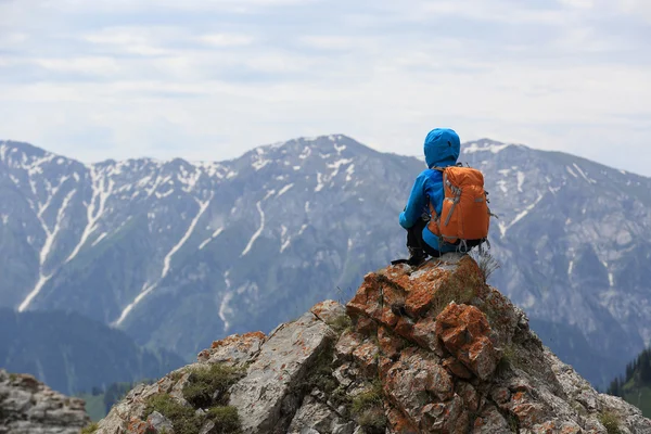 Mochilero sentado en pico de montaña — Foto de Stock