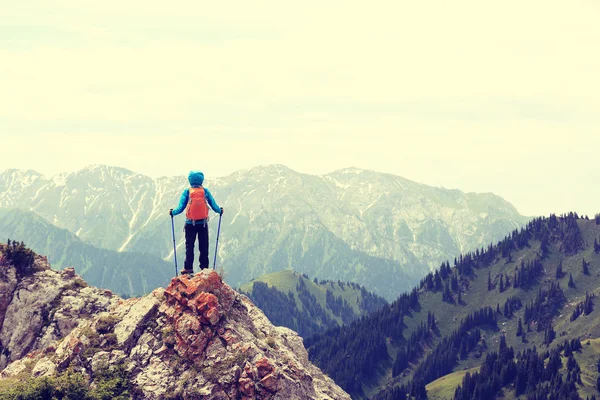 Woman backpacker on mountain peak cliff — Stock Photo, Image