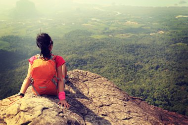 dağ tepe üzerinde oturan backpacker 