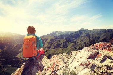 dağ tepe üzerinde oturan backpacker 
