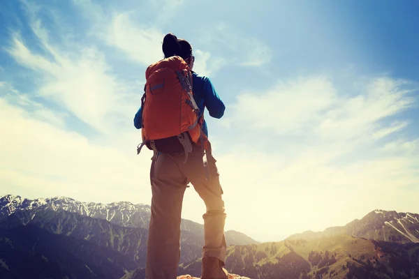 Backpacker hiking on mountain peak cliff — Stock Photo, Image