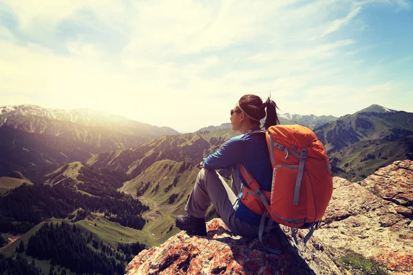 Backpacker sitter på bergstopp — Stockfoto