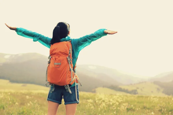 Woman backpacker in grassland — Stock Photo, Image