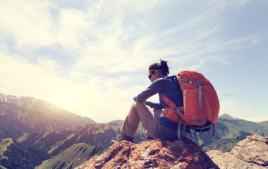 dağ tepe üzerinde oturan backpacker 