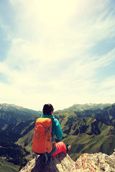 Backpacker sitting on mountain peak — Stock Photo, Image