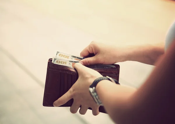 Las manos sacando dinero de la billetera — Foto de Stock