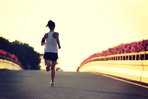 Mujer corriendo en la ciudad puente carretera — Foto de Stock