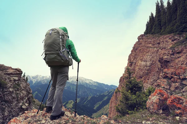 Backpacker hiking on mountain peak cliff — Stock Photo, Image