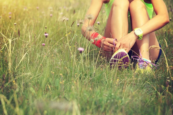 Young woman runner tying shoelace — Stock Photo, Image