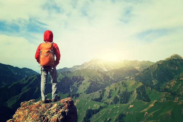 Backpacker hiking on mountain peak cliff — Stock Photo, Image