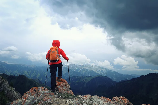 Backpacker piesze wycieczki na szczyt góry klif — Zdjęcie stockowe