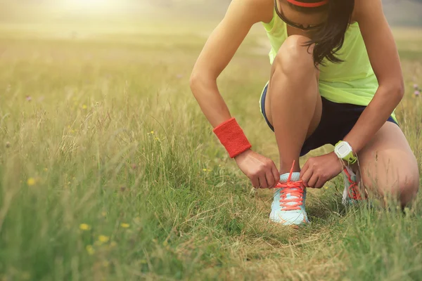 Молода жінка бігун зав'язує шнурки — стокове фото