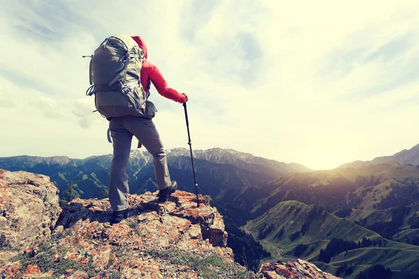 Backpacker vandring på berget peak klippa — Stockfoto