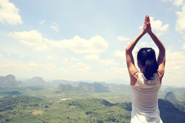 Mujer haciendo yoga en el pico de montaña — Foto de Stock