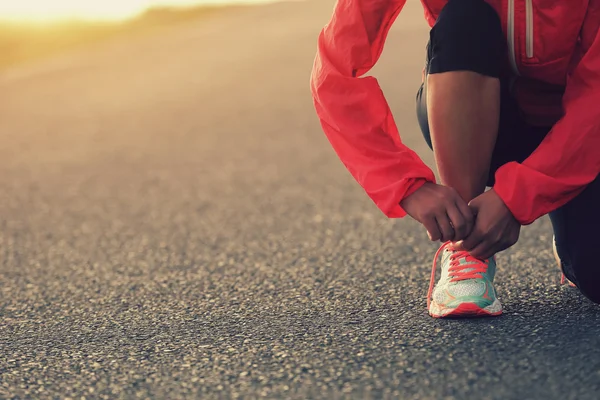 Woman runner tying shoelaces — Stock Photo, Image