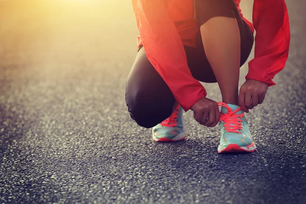 Giovane donna corridore legatura shoelace — Foto Stock