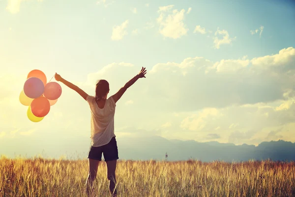 Mujer al atardecer con globos de colores — Foto de Stock