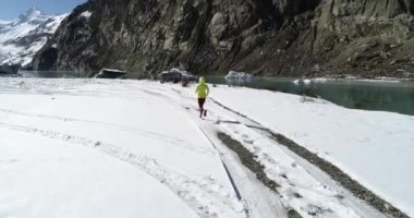 Kış doğasında koşan kadın koşucu. Hava görüntüsü drone görüntüleri, yavaş çekim