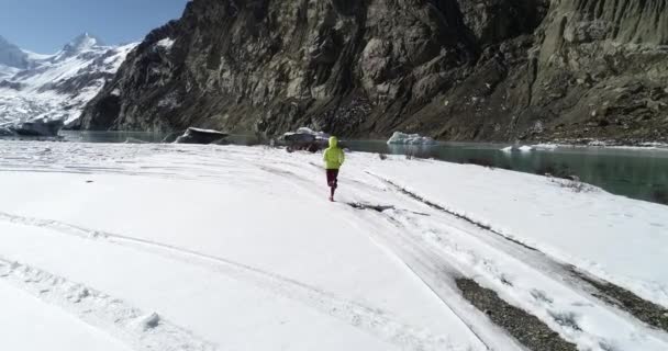 冬の自然界を走る女トレイルランナー 空中ビュードローン映像 スローモーション — ストック動画
