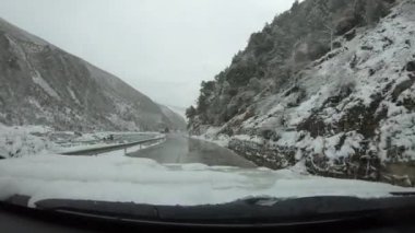 Kış günü karlı dağ yolunda giden off road arabası.