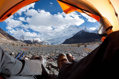 Yürüyüşçüler çadırdaki güzel manzaranın tadını çıkarırlar.