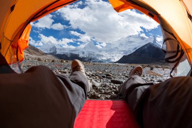 Yürüyüşçü çadırdaki güzel manzaranın tadını çıkar.